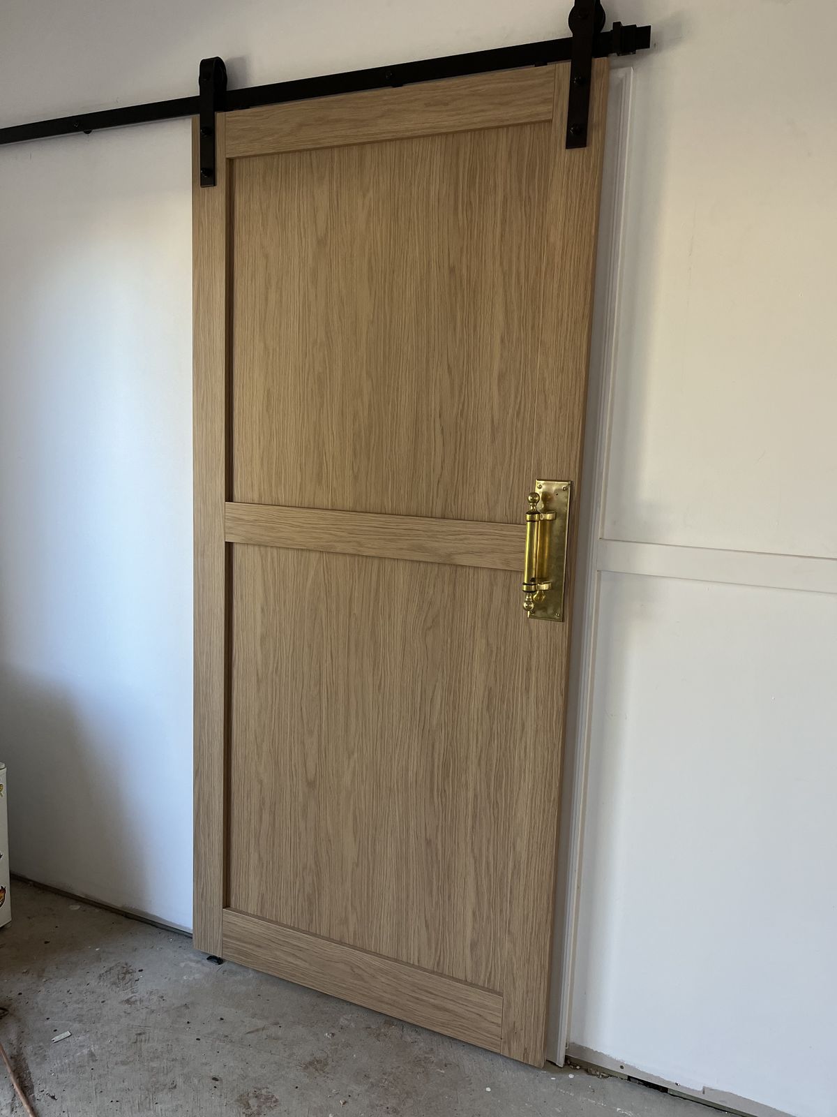 Timber cabinetry with a sliding barn-door front and black hardware