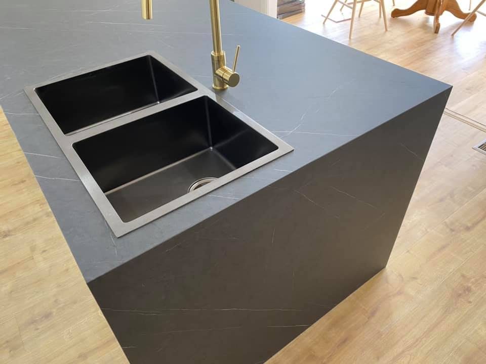 Charcoal stone waterfall island with brass mixer tap