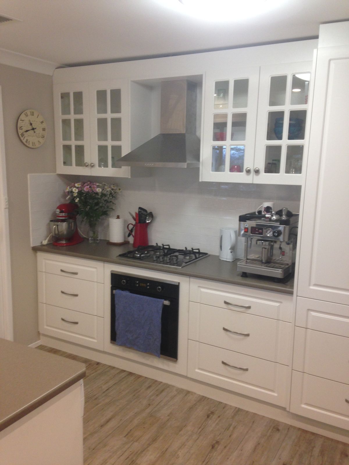 Classic cottage-style kitchen with glass display cabinets and white joinery