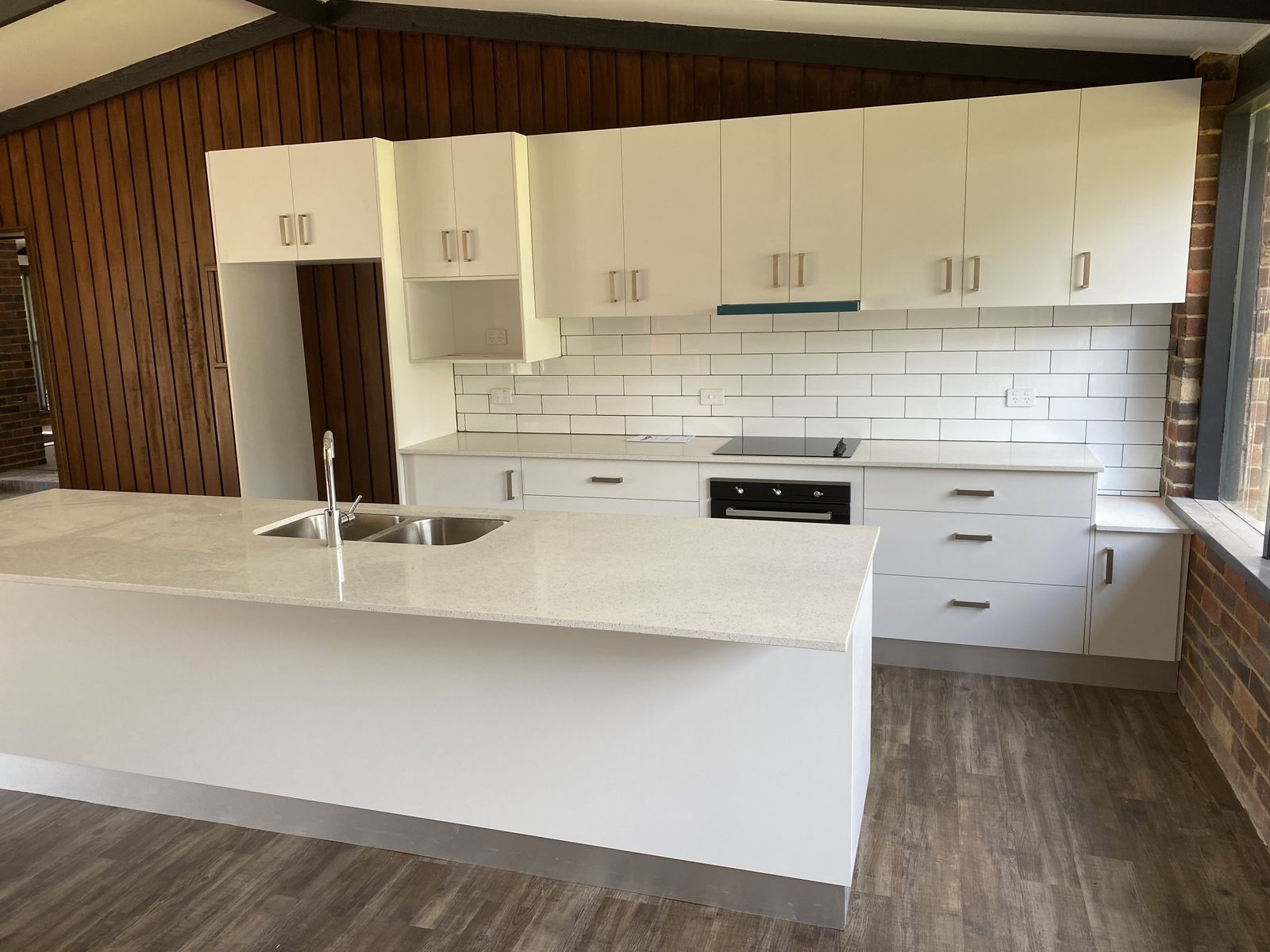 Custom kitchen with white cabinetry, timber ceiling and subway tile splashback