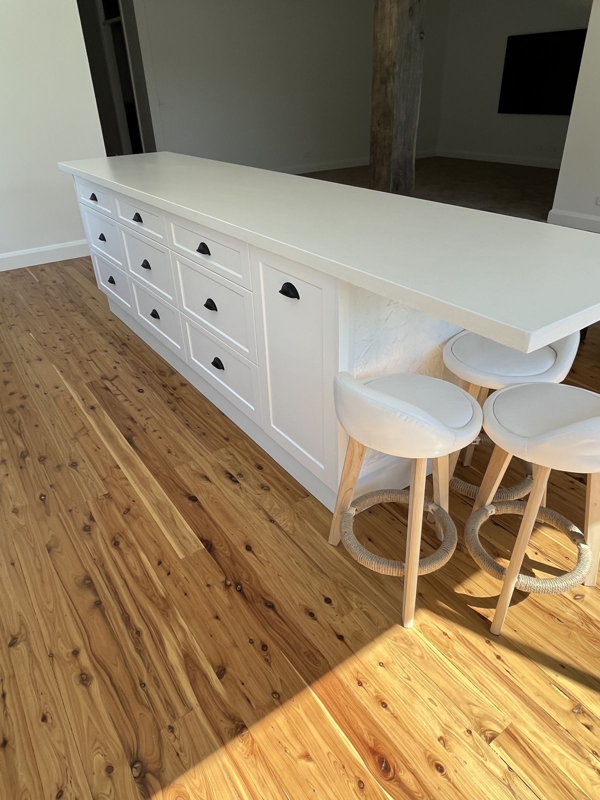 Kitchen island unit with timber-lined ceiling and pendant lighting