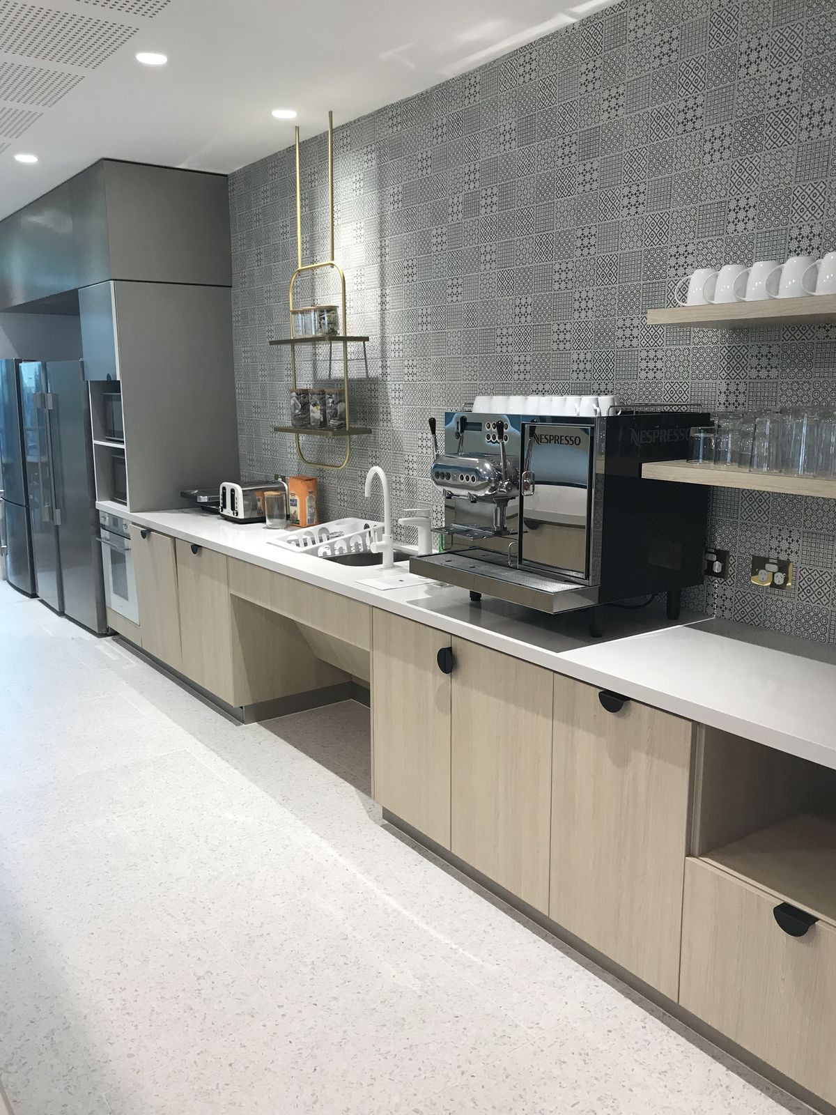 Mid-century style kitchen with pale timber cabinetry and stone benchtops