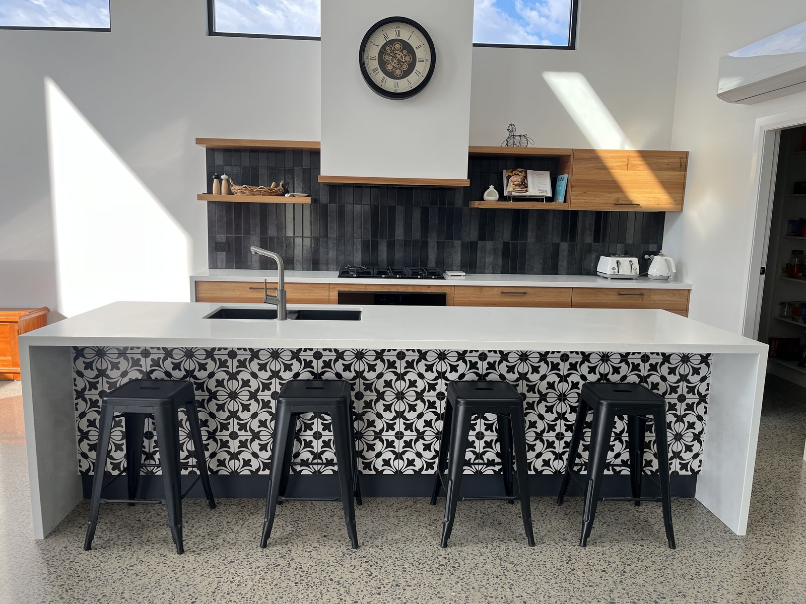 White shaker kitchen with stone island, timber shelving and servery window