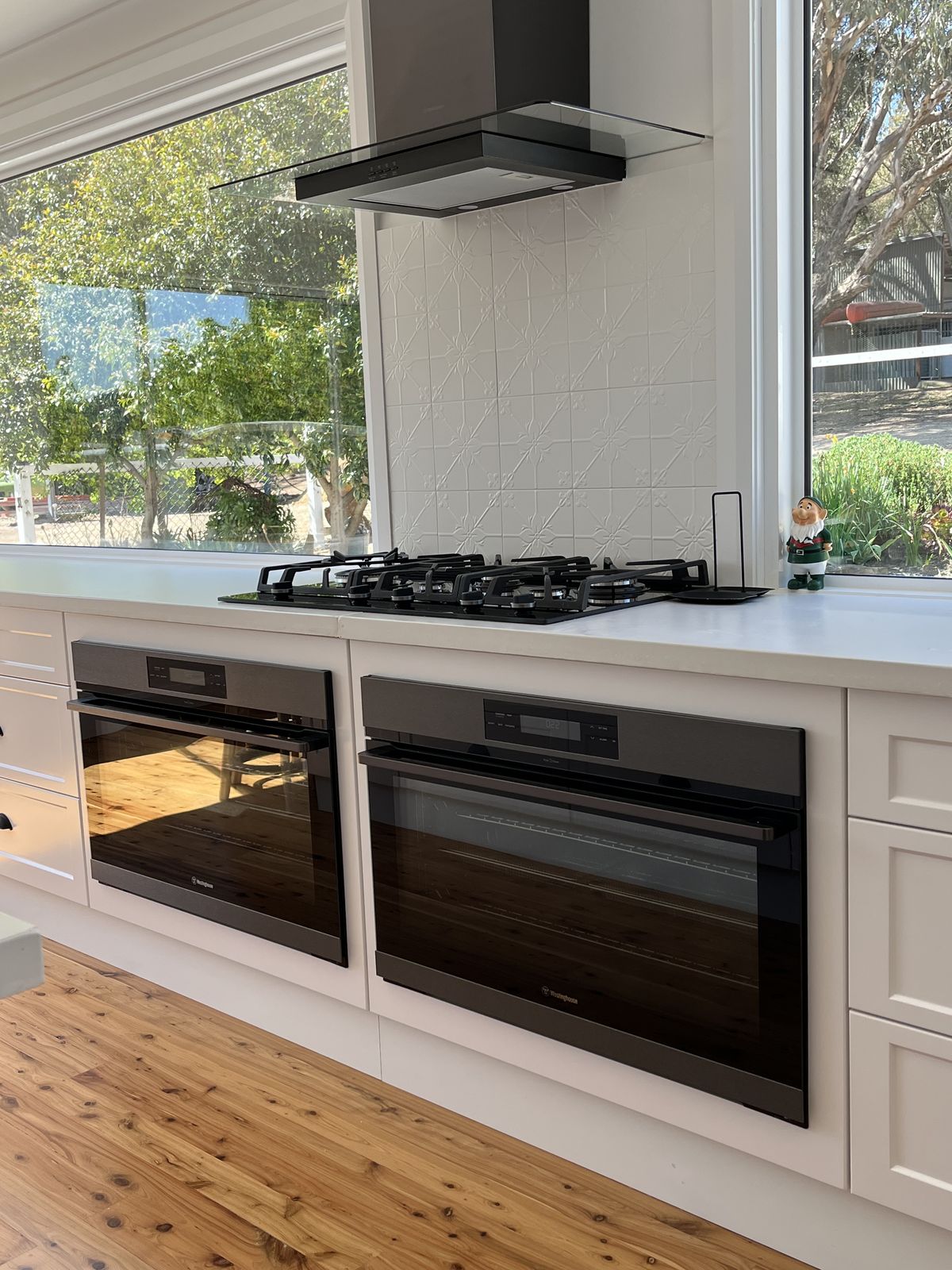 White kitchen with engineered stone benchtops and matte black tapware