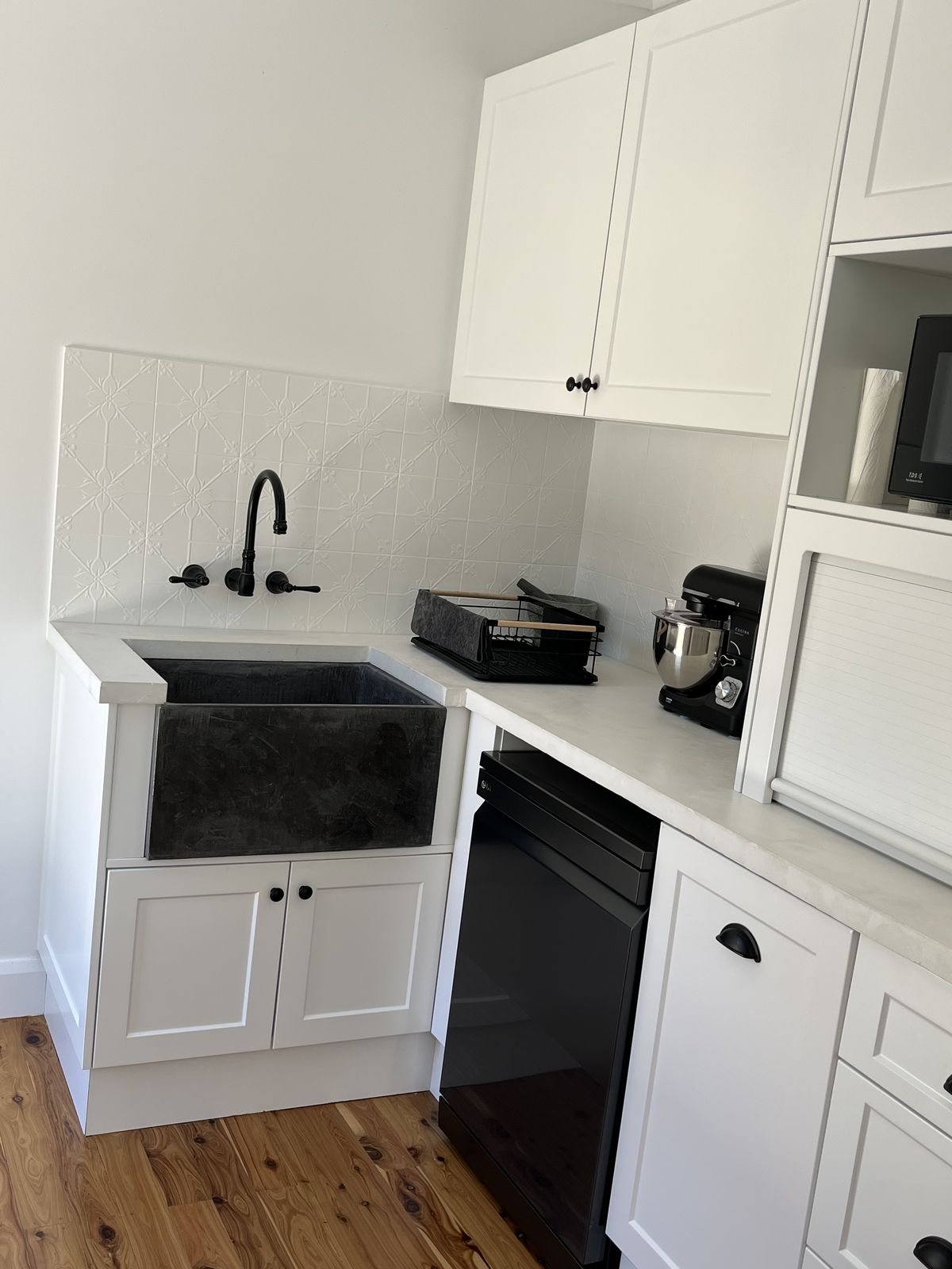 Bright white shaker kitchen with island and warm timber flooring