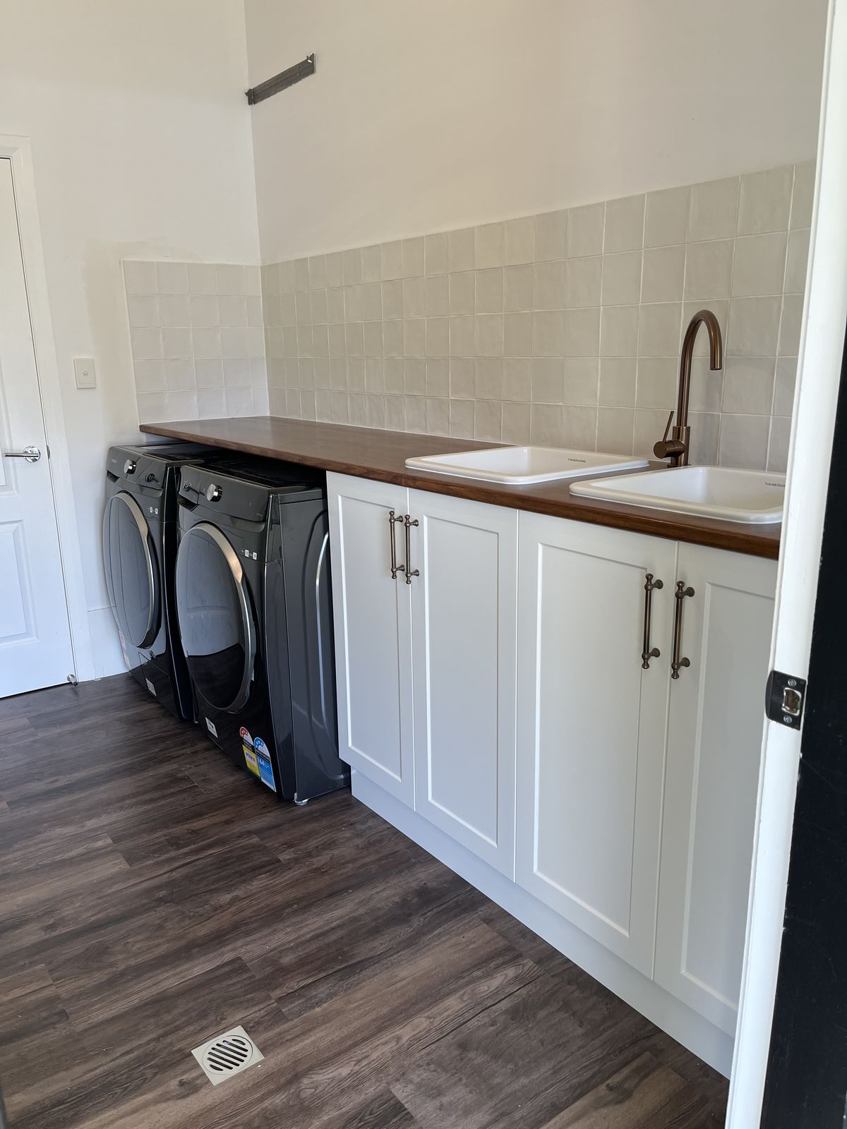 White laundry with stacked washer/dryer recess and barn-door storage