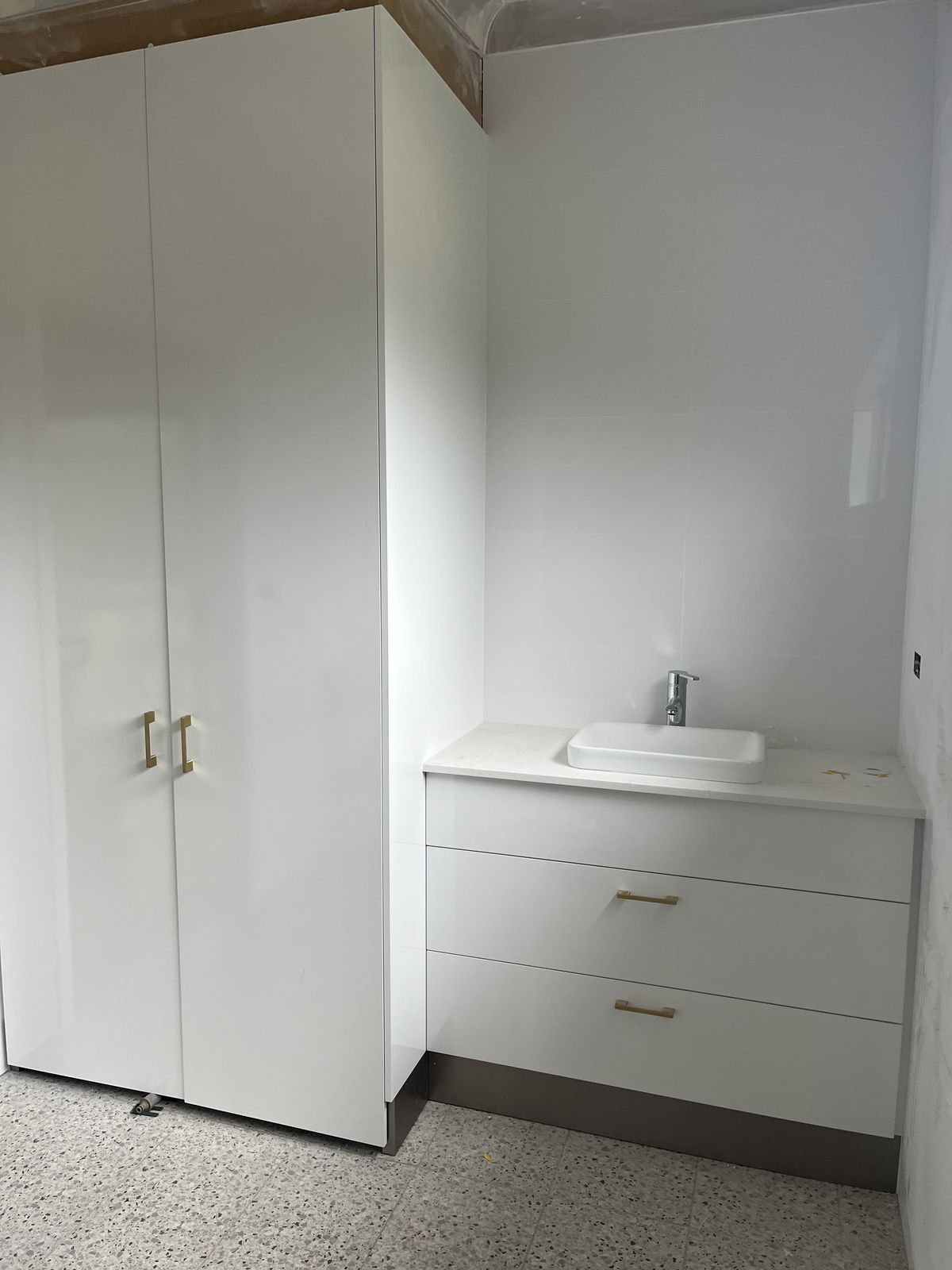 Full-height white laundry cabinetry with concealed storage