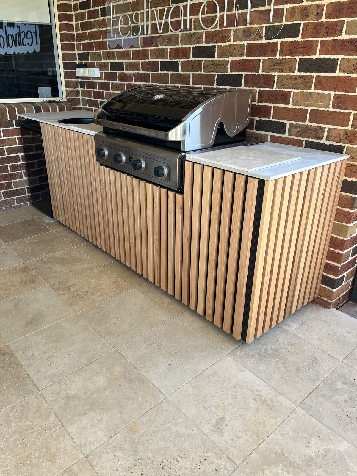 Outdoor BBQ cabinetry with timber batten front and tiled surround