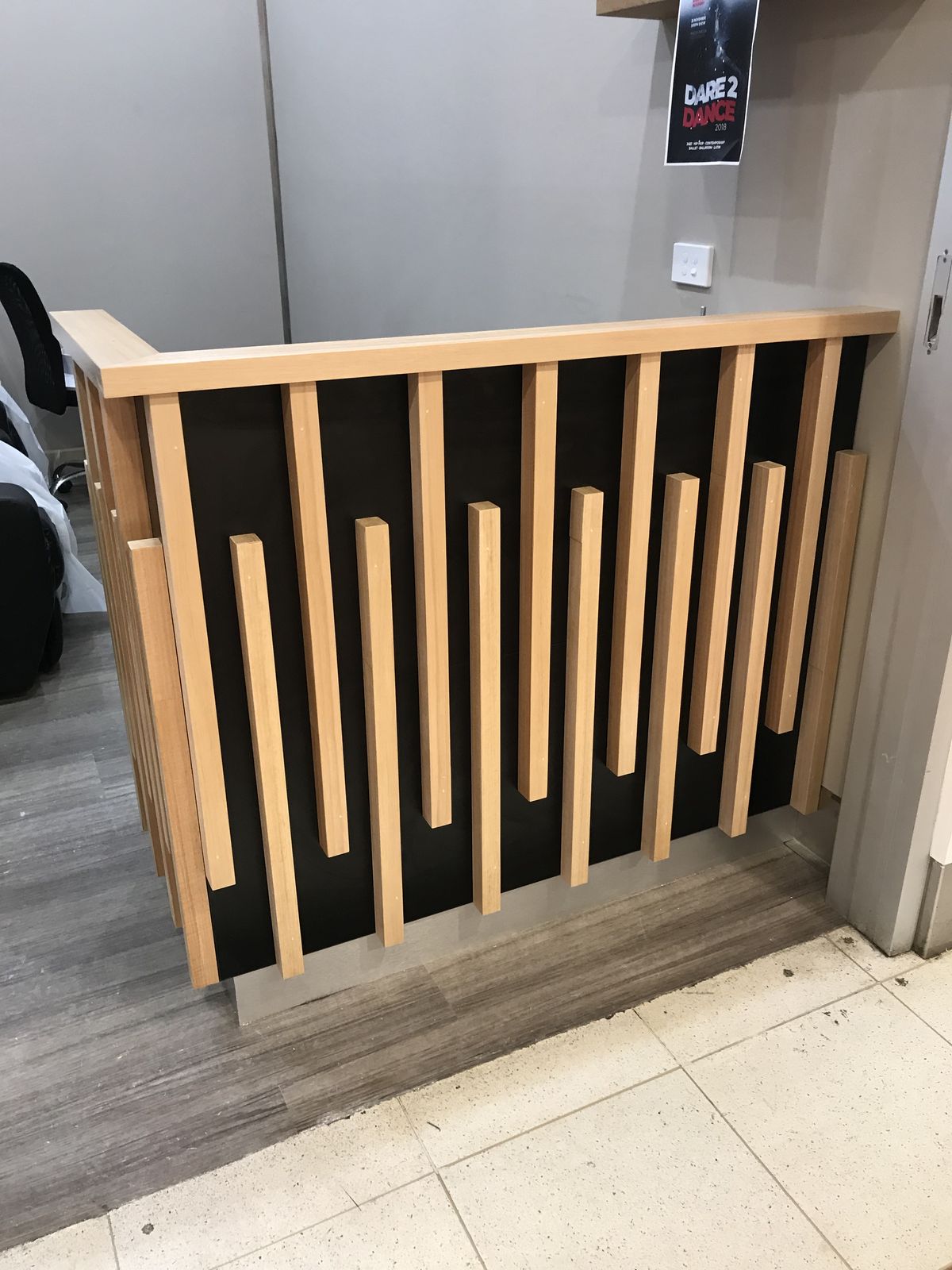 Curved timber reception desk with white stone counter