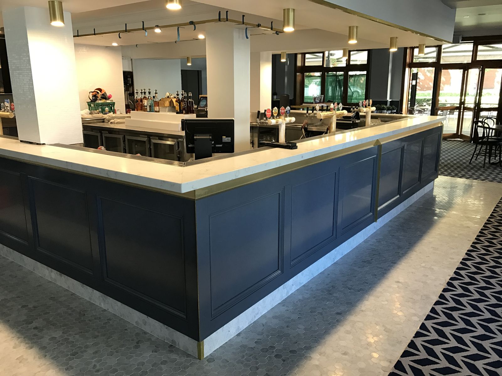 Navy and stone commercial bar counter with brass detailing