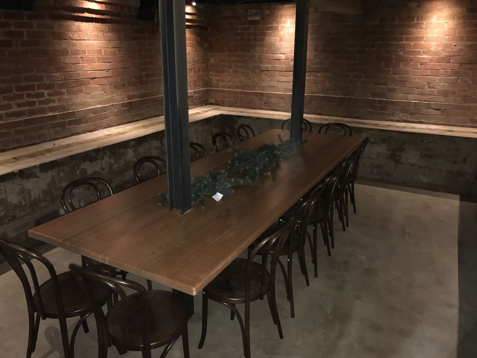 Custom timber communal dining table with steel supports in a venue