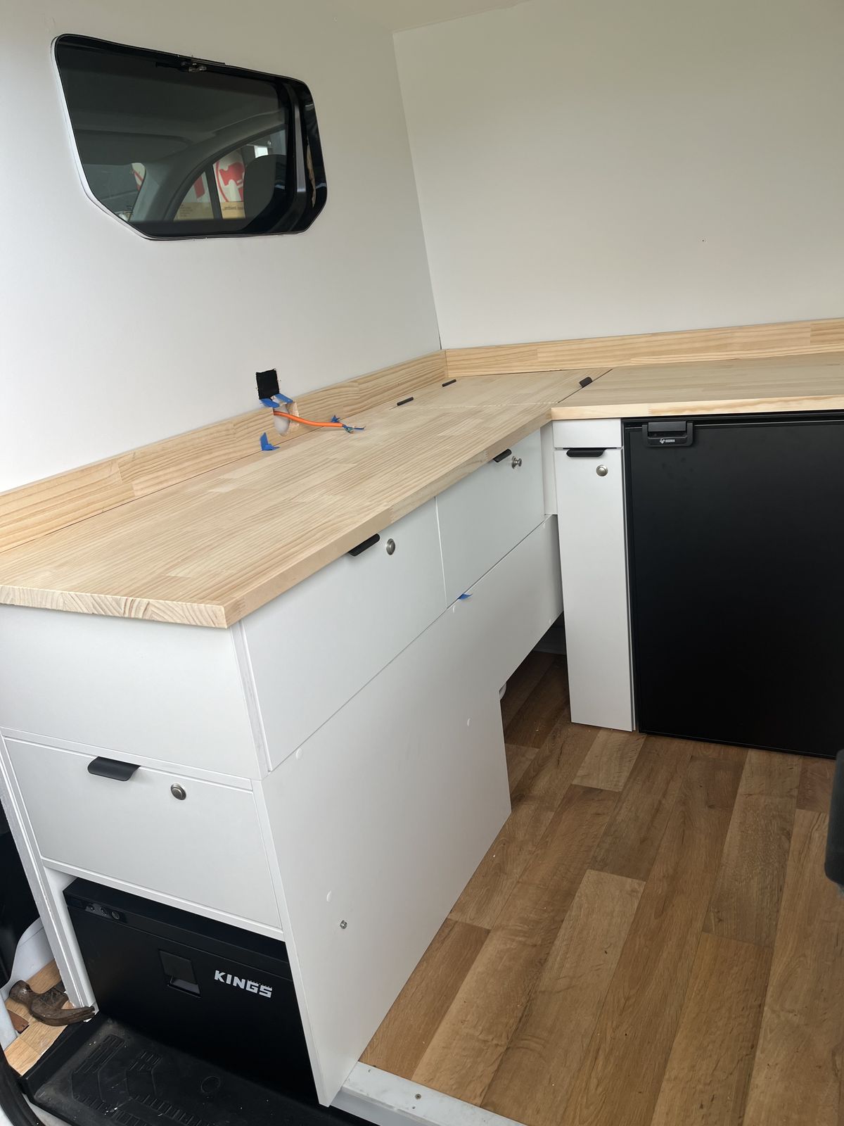 Custom timber and white storage fit-out inside a work van
