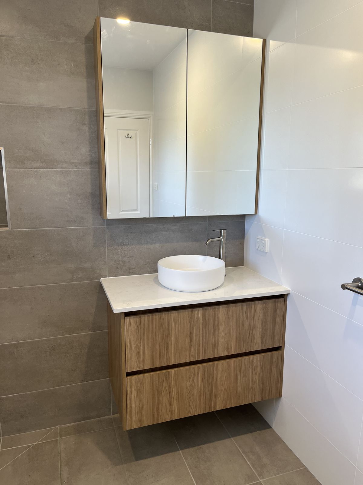 White vanity paired with a matching timber shaving cabinet