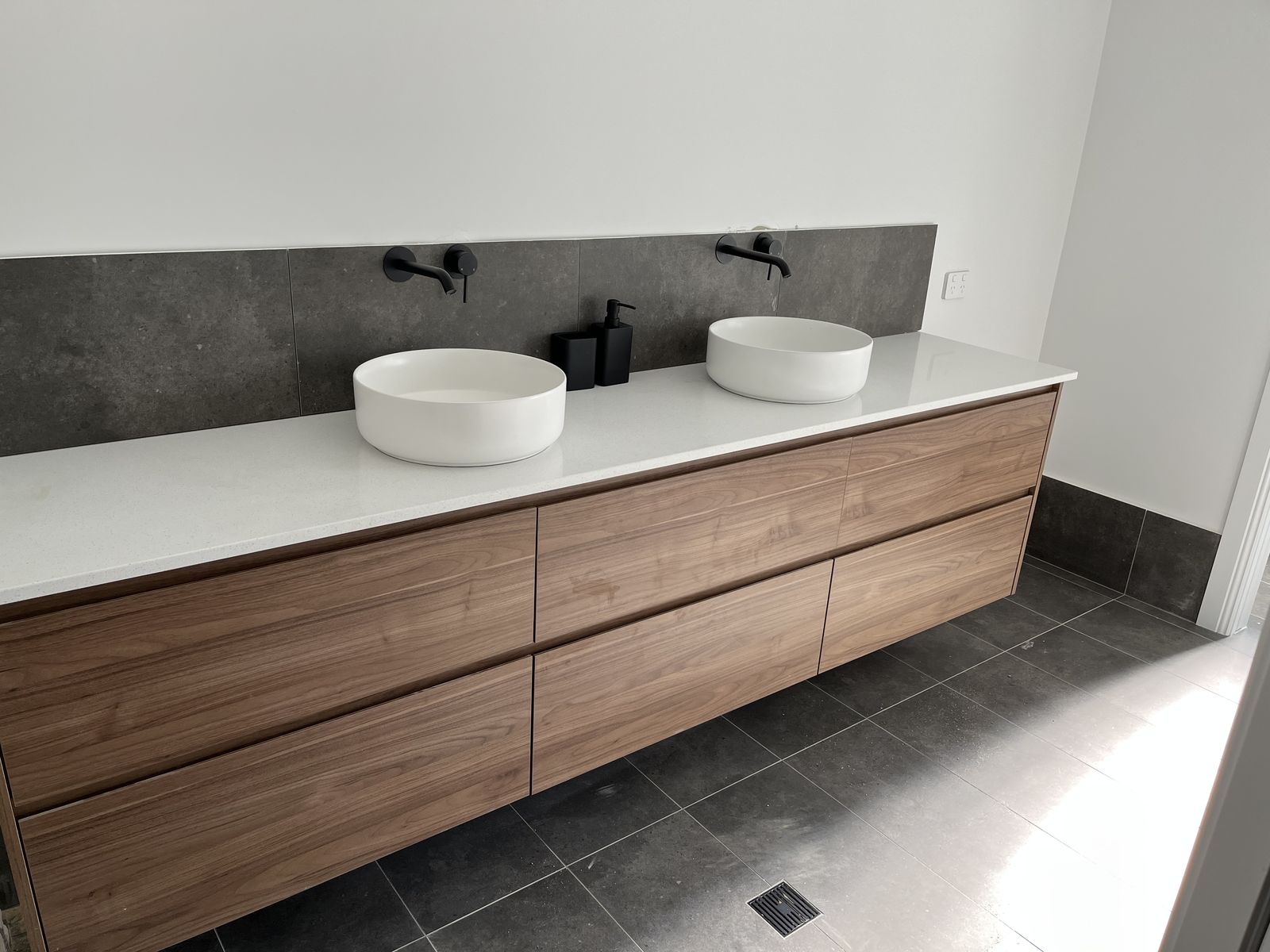 Timber vanity with white stone top and twin vessel basins