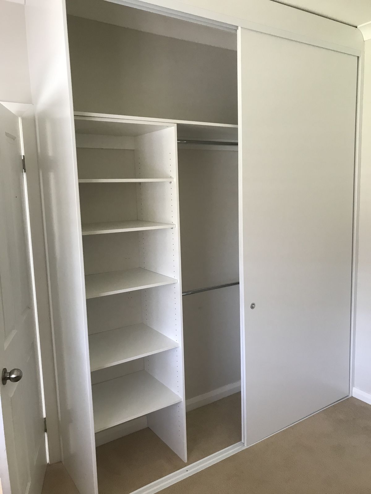Bright white wardrobe fit-out with adjustable shelving and drawers